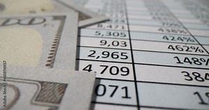 Table sheet with commercial data in cells and dollar bill on document. Business analytics performance and collection. Columns with corporate information in office