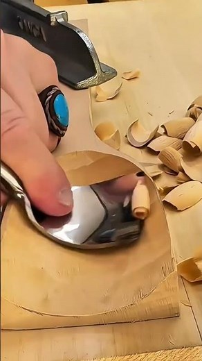 scooping and hollowing out a square wooden block using a sharp curved hand gouge to create a bowl