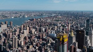 TIME LAPSE: Daytime New York City time lapse on top of the Empire State Building with Manhattan, Williamsburg Bridge, and East River in background. Slow tilt down movement.