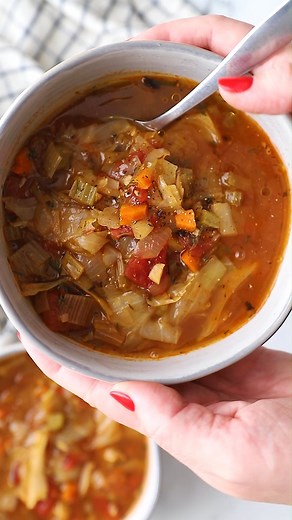 This healthy Cabbage Soup recipe is low in calories, coming in at only 91 calories per cup, but the best part is that it is big on flavor! The lemon, dill, garlic and touch of caraway are so delicious with the tender cabbage and hearty veggies. This high-fiber bowl of goodness is 100% meatless, and will keep you full without weighing you down. Ingredients: 3 tablespoons olive oil, plus more for serving 6 cloves garlic, finely chopped 1 large sweet onion, diced 1 large leek, white and light green