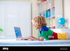 Child doing homework on computer. Online class. Homeschooling and remote learning. Little school boy reading on monitor screen. Kids play video game Stock Photo - Alamy