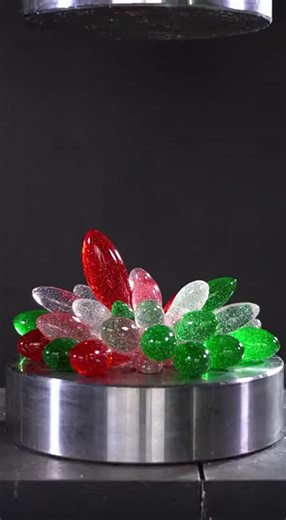 Nic Davis on Instagram: "Watch as a stunning cluster of red, green, and white glitter-frosted glass icicles gets crushed under a hydraulic press. The icicles shatter one by one, releasing a mesmerizing flow of glittery liquid in festive holiday colors!"