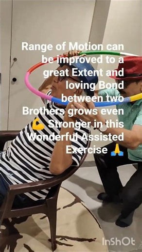 Assisted hoola hoop upper body exercise of senior parkinsons Brother assists brother on the chair