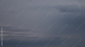Time lapse overcast sky with grey spindrift clouds while getting dark to night sky. Dramatic sky background. Cloudscape with dark cloud formation from dusk to night darkness