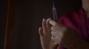 Female hands preparing for injection.