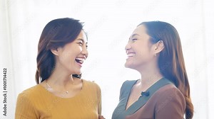 Two friends smiling at each other, enjoying the moment. Concept of female friendship and mutual understanding.