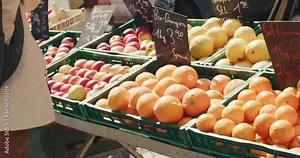 Woman buying fruits in downtown Stuttgart produce market on street in afternoon, Germany, Europe, panning view angles