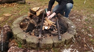time lapse while man using propane torch to light up wood in the fire pit.