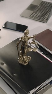 No people vertical footage of lawyers workspace with many folders, documents and Lady Justice figure on office table in modern law firm