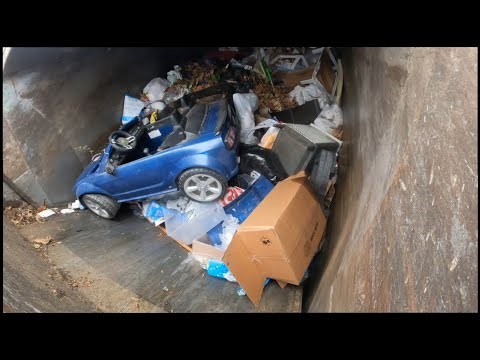 Waste Management front load truck smashing garbage