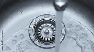 Streaming water in sink. Water stream going down the drain. Stock Video