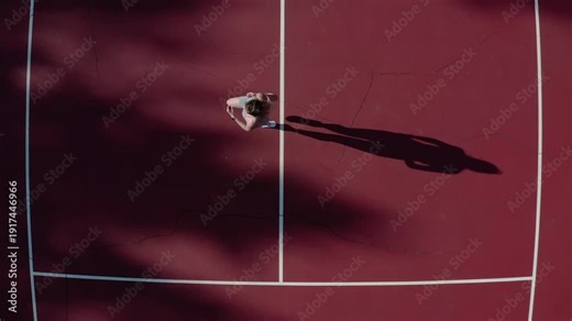 Young athletic blonde woman doing run exercises on a sports court during a sunny day. Energetic workout, healthy lifestyle, fitness motivation.