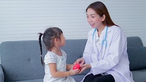 Asian beautiful woman doctor health check up cute little girl They both sat on the sofa. Concept of medical services in hospitals, children's health checks.