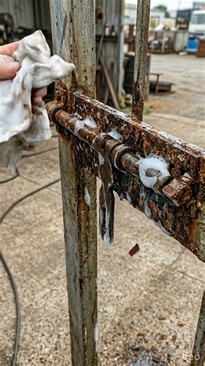 Hand sprays rust off lock