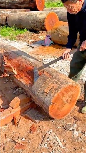 splitting and shaping a large wooden log manually using a sharp traditional axe