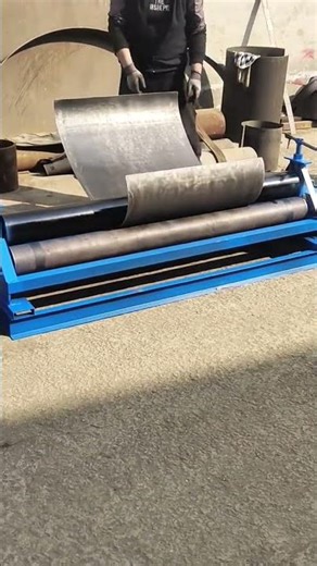the process of bending heavy steel plates using industrial rolling machines for metal fabrication