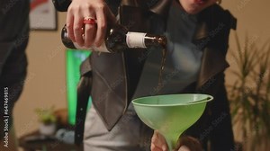 Group of cheerful multiethnic young people playing drinking games with alco while having fun together during house party at weekend