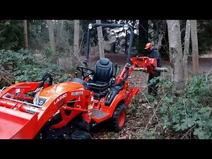 Kubota Bx23S Backhoe with thumb picking up and cutting logs with Stihl MS 260