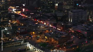 Lively nightlife of downtown Nashville from above. Bright city lights, busy streets, including Broadway and terrace restaurants, and iconic buildings make for a captivating urban scene