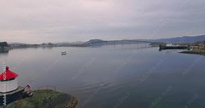 4k: Boat pasing smal light house on islet and boat passing with bridge in background. Shot on drone.