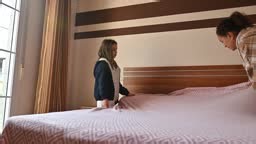 Mutter und Tochter machen morgens gemeinsam das Bett