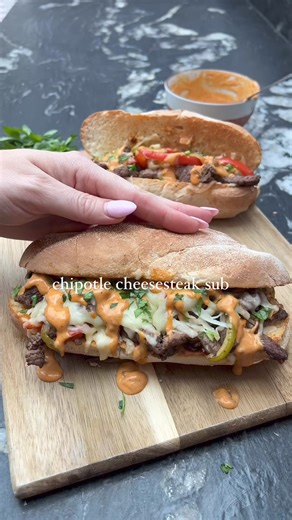 Chipotle Cheesesteak Sub 🤤 OBSESSED with this quick and easy dinner recipe 😮‍💨 peppers and onion fried until soft tossed with thinly sliced steak, piled in a sub roll with plenty of cheese and a gorgeous chipotle sauce 💅🏼 527 calories and 42g protein per sub 🫶🏼 Hit SAVE for your next steak night recipe 📌 Ingredients (serves 2): 200g steak (we used Rump - Sirloin or Ribeye would work here too) Tsp chopped garlic White onion thinly sliced Small red pepper thinly sliced Small green pepper t