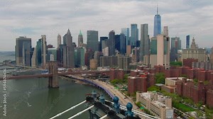 Aerial of downtown NYC Brooklyn Bridge over Manhattan Bridge east river FDR drive traffic with New York City financial buildings in background