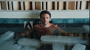 Sports Man Diving into Cold Water of Swimming Pool with Ice Cubes for Strong Body Health. Handsome Person in Bathtub Filled with Frost Liquid for Youth Treat. Healthy Activity of One Guy in Icy Bath