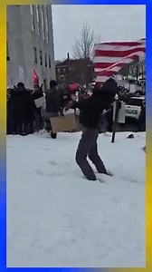 A masked counter-protestor at the "March Against Mills" yesterday slams an upside down American flag into the ground. These are the people who support Governor Mills and Speaker Fecteau... | The Maine Wire