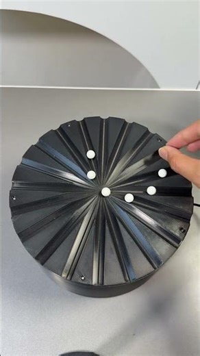 This item is a kinetic desktop sculpture designed to create optical illusions through motion.