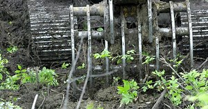 Excavator backing up pulling claw to rip up trees as it clears the forest Stock Video