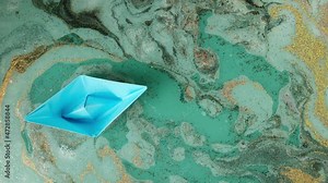 Bath bomb in water close-up. Swimming paper boat. Soap ball dissolving, foam bubbles and golden and black glitter powder. Decorative cosmetic products for bathroom concept. Beauty and spa concept.