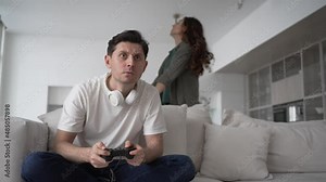 Young couple of wife and brunet husband playing non-stop computer game in headphones argue over man gambling addiction in living room Stock Video