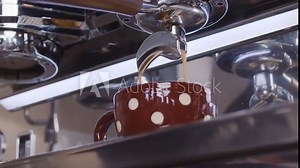Idyllic slow-motion close-up of an industrial coffee maker pouring fresh coffee in a cup to keep up with the routine. Coffee industry and coffee shop concepts. Shot in 6K.