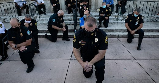Police officers kneel and march in solidarity