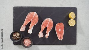 Time lapse. Farm-raised salmon steaks on a slate board.