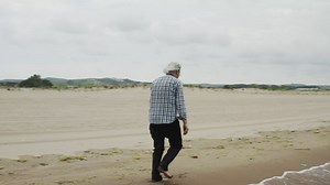 Old man walking by the shore - Free Stock Video