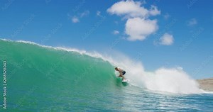 Surfer riding and crashing in the barrel of epic ocean wave in slow motion, surfing paradise adventure lifestyle, surfing wipeout