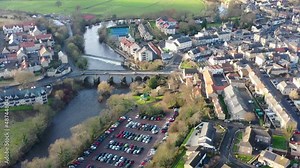 Aerial footage of the town centre of Wetherby in West Yorkshire in the UK, showing the River Wharfe with traffic driving over the small bridge that leads in to the town centre, taken in the winter.