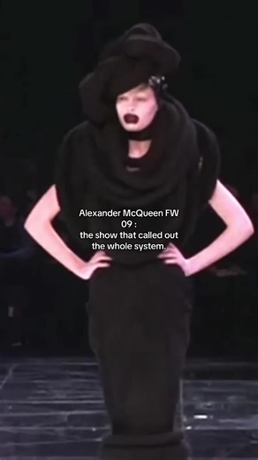 Alexander McQueen Fall/Winter 2009 ready-to-wear was shown in Paris on March 10, 2009 at the Palais Omnisports de Paris-Bercy. The set was built as a scrap heap of debris from McQueen’s past shows, surrounded by a shattered-glass runway. The clothes were designed as high-drama riffs on landmark 20th-century fashion codes: houndstooth New Look references and Chanel-style tweeds, then sharp orange-and-black harlequin looks, then pieces that loop back to McQueen’s own archive. The styling kept the 