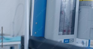 Close-up an anesthesia workstation with pipeline inlet pressure is standing at the medical room and someone is elevating the level of oxygen, air, nitrogen oxide.