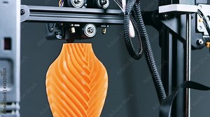3D Printer printing a vase for home decoration with orange plastic Filament.