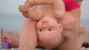Mother and baby playing on beach. Mom and child on seaside at summer vacations