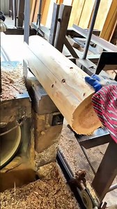 The operator guides the spinning saw as it slices through the log