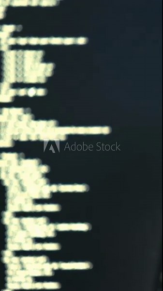 Defocused white code lines on a dark terminal screen, evoking programming and command-line output