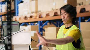 Warehouse worker scanning airway bills labels applied on cargo packages, monitoring shipping route on package tracking software. Registering the details for the logistics. Camera B.