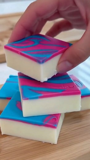 Easy Cotton Candy Fudge Whimsical Pastel Swirl Cotton Candy Fudge Delight Ingredients: 3 cups white chocolate chips 1 (14 oz) can sweetened condensed milk 1 teaspoon vanilla extract 1/2 teaspoon cotton candy flavoring Pink gel food coloring Blue gel food coloring 1/4 cup pastel sprinkles (optional) Directions: Line an 8×8-inch pan with parchment paper. In a microwave-safe bowl, combine white chocolate chips and sweetened condensed milk. Microwave in 20–30 second intervals, stirring until smooth