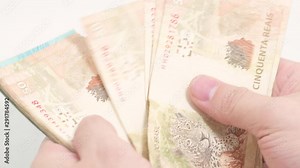 Counting Brazilian real banknotes. 50 and 100 reais brl. Brazilian money, real notes. Hands sliding money bills.