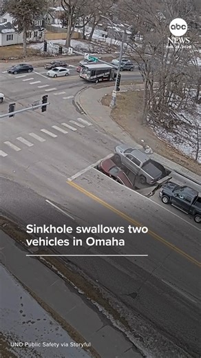 Dramatic surveillance footage captured the moment two vehicles were suddenly swallowed by a sinkhole as they waited at an intersection in Omaha. Police praised bystanders for jumping into action to help the drivers involved. https://abcnews.visitlink.me/zyFjxp | ABC News