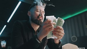 Bearded man counting money while he smokes - Free Stock Video